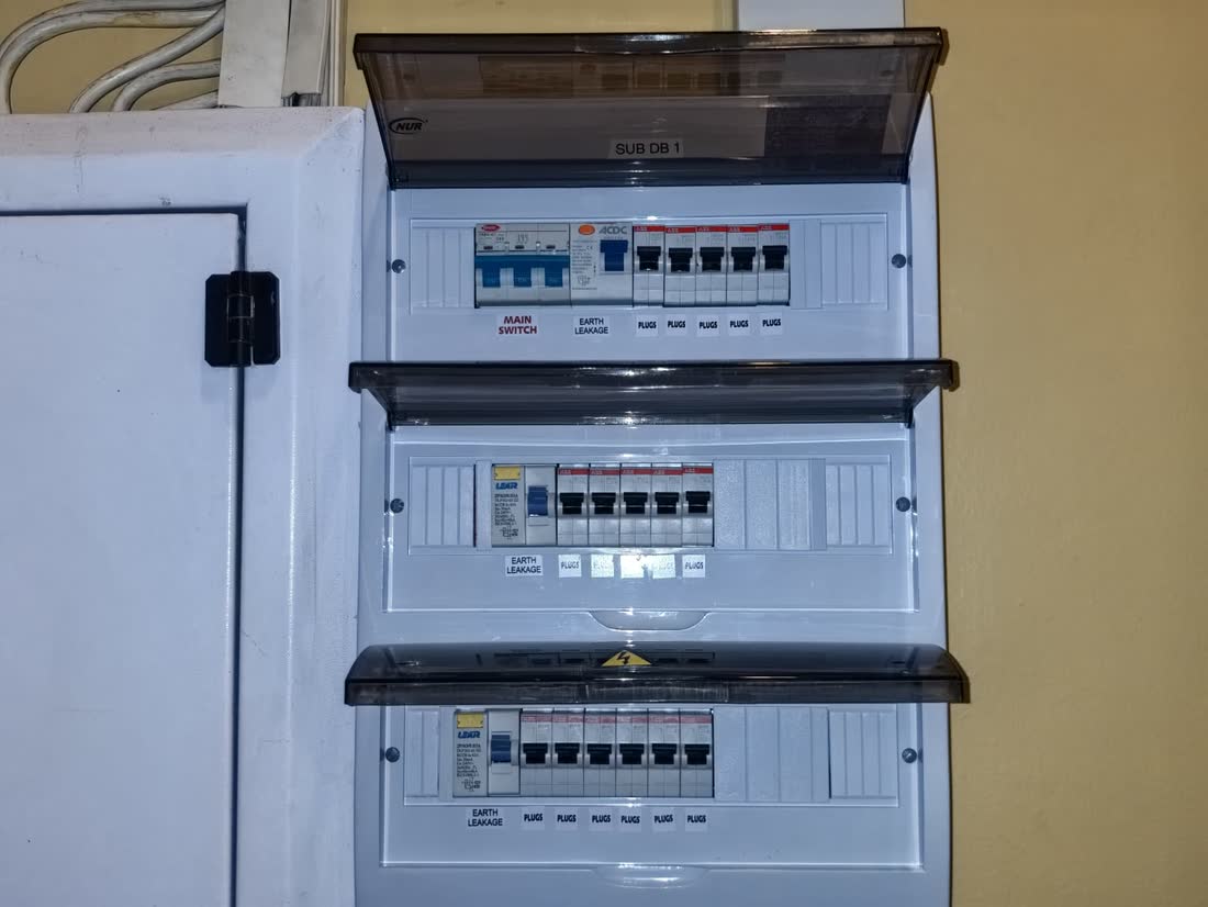 An open distribution board with rows of circuit breakers and labelled circuits